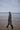 Person walking on a beach with a gray  Tanta Rainwear coat
