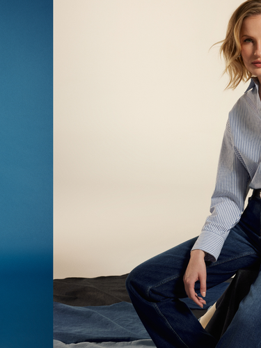 Woman wearing a light blue striped shirt and dark jeans from COJ Denim in two different poses against blue and beige backgrounds.
