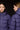 Two people wearing purple puffer jackets from Tanta Rainwear against a black background