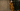 Woman in a mustard suit from Masai standing against a textured wall and black door.